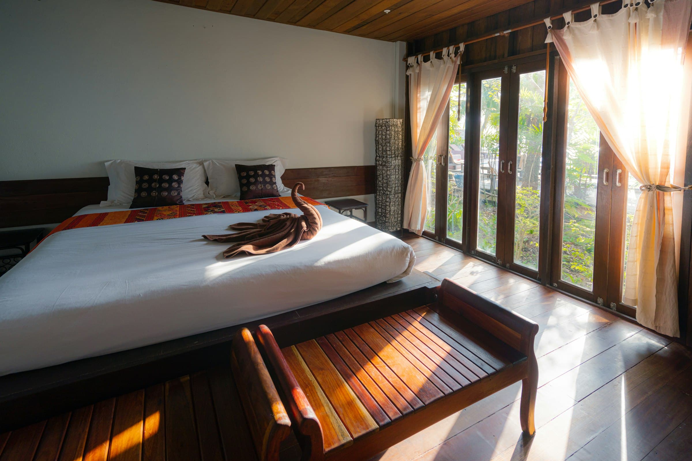 Sunlit luxury suite with linen bedding and warm wood accents