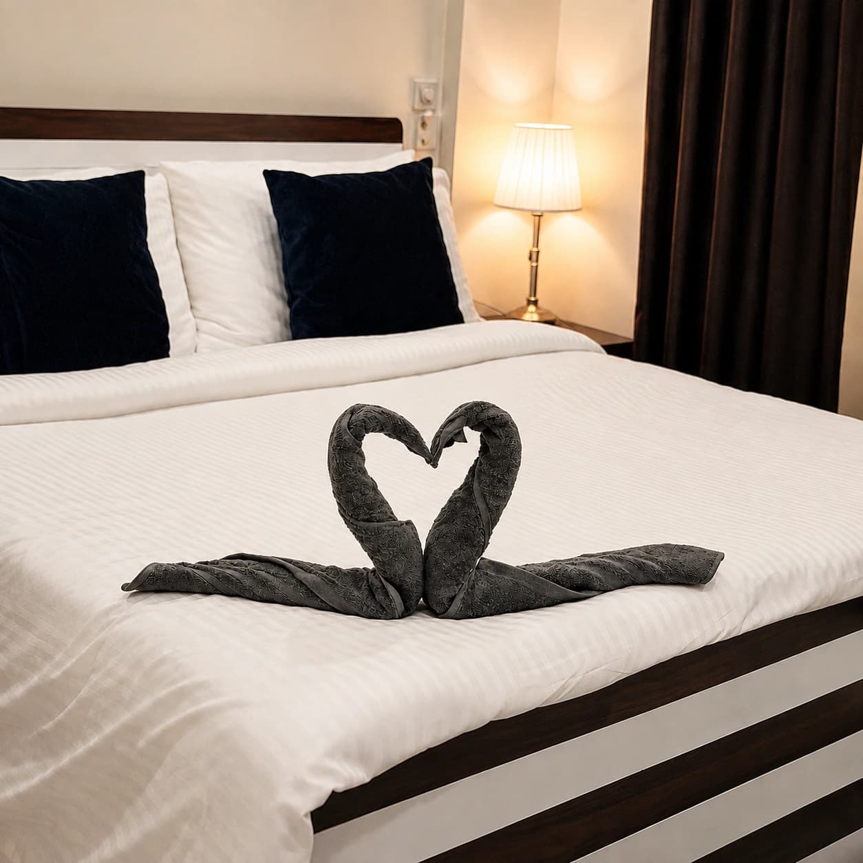Deluxe Double Room: Made bed with swan towel fold and bedside lamp
